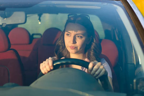 woman driving a car.serious woman in the car.Driving a car as a hobby.Renting a car.confident woman driving.problems on the road.emotional girl in the auto.holding the steering wheel.woman with car.upset girl.portrait.woman in the car.girl is nervous