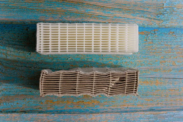 stock image clean and dirty vacuum cleaner filter.vacuum cleaner filter replacement.vacuum cleaner cleaning.new filter.dirt and mold.health hazard.dirty air.air filtration.air purification system.vacuum cleaner.air filter.vacuum cleaner repair.house cleaning.