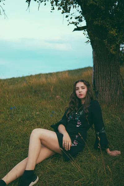 드레스를 아름다운 풀밭에 여자가 아래앉아 로움을 느낀다 외로움 비밀을 여자가 — 스톡 사진
