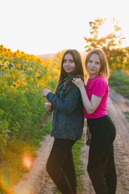 Mutlu kızlar. Kız arkadaşlar doğada sarılıyor. Kadın arkadaşlığı. Doğada dinleniyor. Tatlı bir gülümseme. Esmer ve sarışın..