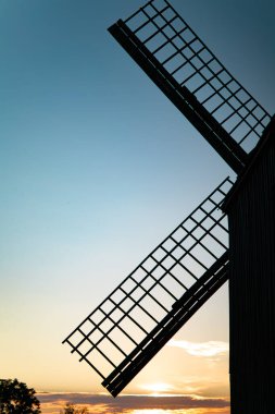 Ukrayna 'daki eski ahşap değirmen. Mimarlık abidesi. Ukrayna yel değirmeni üretimi. Klasik ahşap yel değirmeni. Masaüstü duvar kağıdı. Mavi gökyüzü. Kırsal manzara. Ukrayna' nın mimarisi.