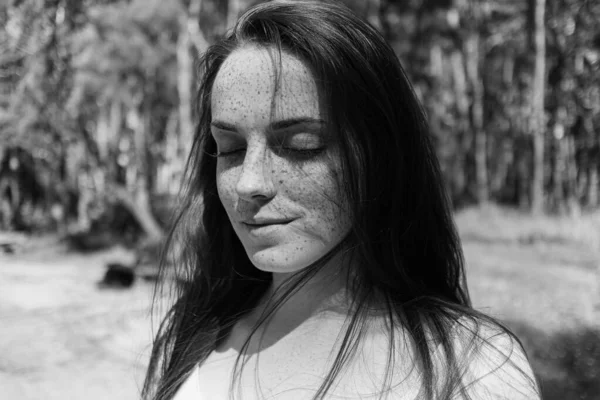 Yüzünde çilli bir genç kadının güzel siyah beyaz portresi. Uzun saçlı, mutluluk ve yalnızlık duyguları olan bir kadın. Ruh sağlığı. Deride çiller.