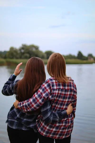 Girlfriends hugging.Girls are walking.Long-awaited meeting.Two women hugging.Friendship and relationships.Happy emotions.True friends.Friends rest in nature.Joyful people.Hugs.Smile.A strong hug.Two girls girlfriends in nature.Beautiful women.
