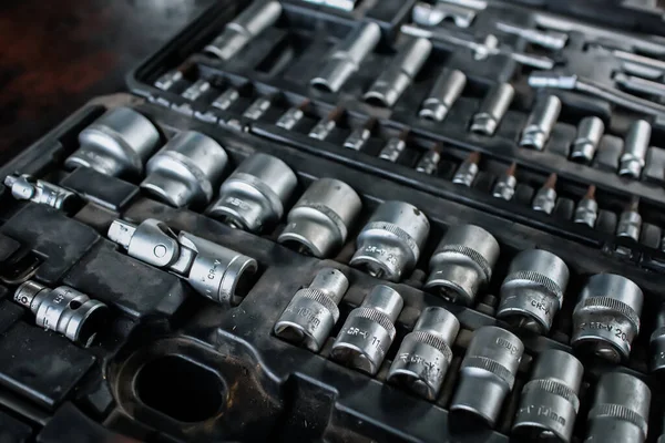 Masadaki araba motor parçaları. Bir çanta içinde bir takım aletler. Araba tamiri. Teknoloji tamiri. Simetri aletleri. Evrensel aletler.