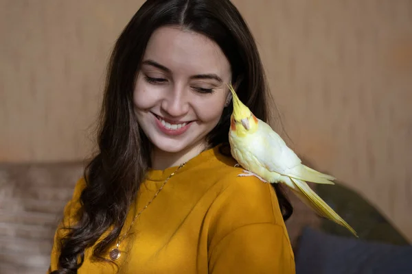 Omzunda papağan olan bir kız. Kuş evcil papağanı olan bir kadın. Bir kızın ve kuşun arkadaşlığı. Papağanlı bir kadının portresi. Evcil hayvanlı mutlu bir kız.