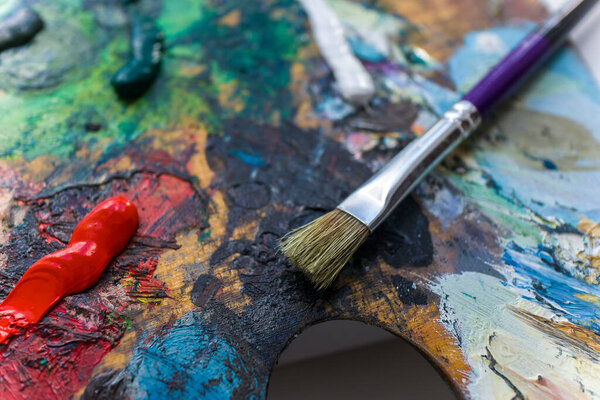 Home hobby.Drawing at home.Art school. Free time.Palette with paints.Drawing with a brush.Oil paints.Brush with paints.Palette of colors.Color mixing.Felite hobby. Художник, увлекающийся рисованием красок.