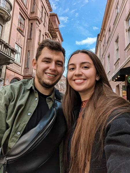 couple of young man and woman in the city.tourists in city.tourists in Europe.couple in love.couple taking selfie.selfie of friends.tourists walking.tourist photo.couple in love taking photo.happy people.girl and guy.boyfriend,girlfriend.