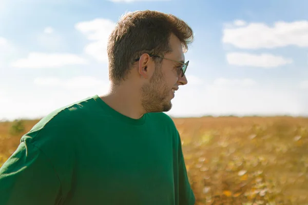 an agronomist in the field looks and checks the harvest.farming.gronomy.man in the field.happy farmer in the field with the crop.young man laughing.field with the harvest.Ukrainian industry.looks.