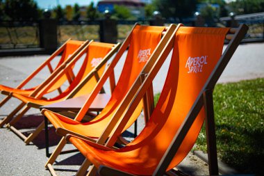 Kharkiv, Ukrayna, 07.07.24 yazlık kafe ve turuncu sandalyeli Aperol spritz. Alkollü içecek Aperol 'ün reklamı ve tanıtımı. Dinlenecek bir yer. Yaz oyun parkı..