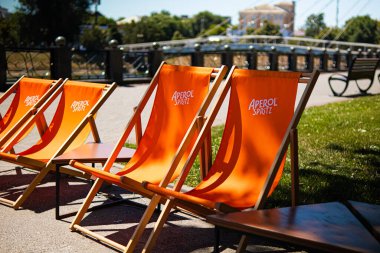 Kharkiv, Ukrayna, 07.07.24 yazlık kafe ve turuncu sandalyeli Aperol spritz. Alkollü içecek Aperol 'ün reklamı ve tanıtımı. Dinlenecek bir yer. Yaz oyun parkı..