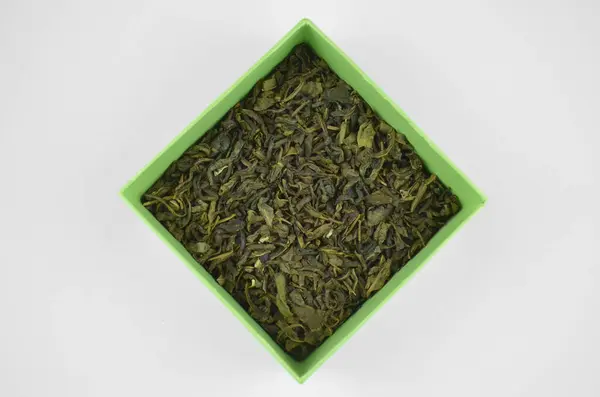 Sarı (kireç) bir kutuda kuru yeşil yaprak çayı, izole edilmiş üst görünüm yakın çekim
