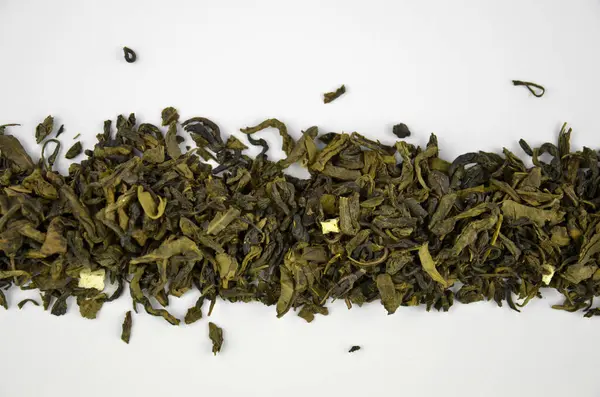 Kuru yeşil yaprak çayı hizalanmış yığın (satır), yakın çekim (makro) izole edilmiş, üst görünüm