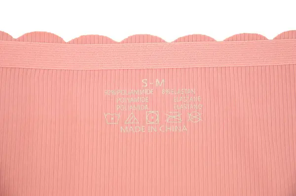 Şeftali pembesi dikişsiz (görünmez) kadın iç çamaşırı (iç çamaşırı, külot, külot) dalgalı kenar izole kapalı iç çamaşırı ve içinde bir etiket ile