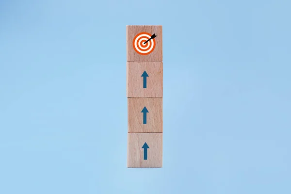 木块堆放在蓝色背景上 顶部有目标图标 战略概念 免版税图库照片