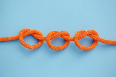 Mavi arka planda bir ipte üç düğüm