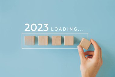 Kadın eli 2022 'ye geri sayım için tahta küp koyuyor. 2022 'den 2023' e kadar yükleme yılı. Yeni yıl başlangıcı konsepti