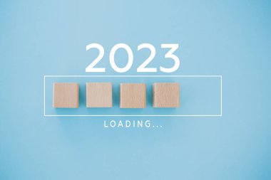 Kadın eli 2022 'ye geri sayım için tahta küp koyuyor. 2022 'den 2023' e kadar yükleme yılı. Yeni yıl başlangıcı konsepti