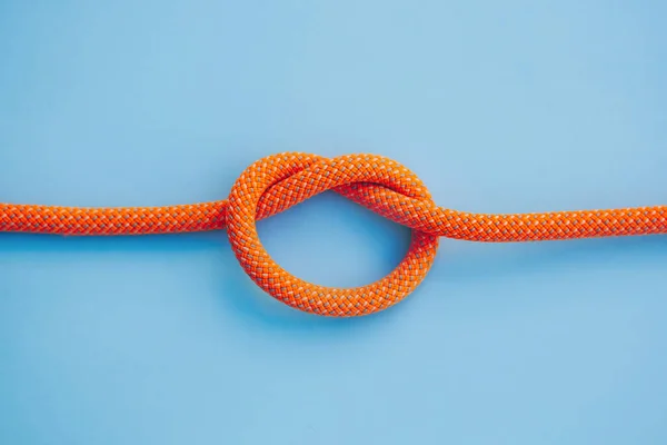 青の背景に結び目を持つオレンジロープ — ストック写真