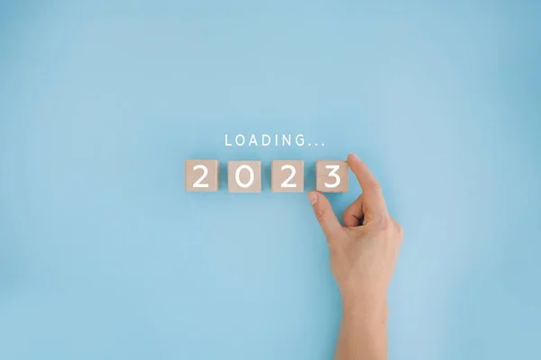 雌性手放置木制立方体倒计时至2022年 2022年至2023年装载年份 新年开始概念 图库图片
