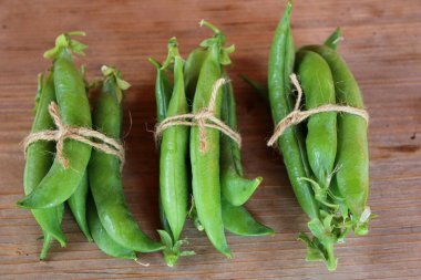 Yeşil bezelye hasadı. Ahşap masada bezelye kabukları. 