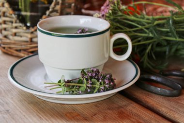 Tahta masada beyaz bir fincan kekik çayı.. 