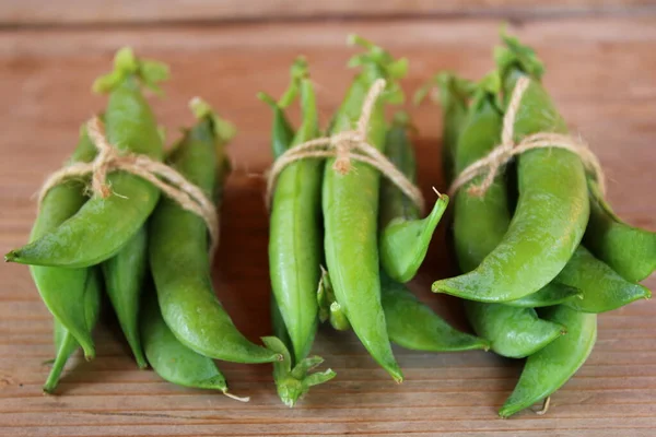 stock image Green pea harvest. Peas pods on the wooden table. 