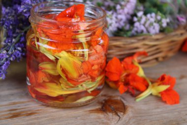 Alkol ve sepetin içindeki otlar turşulu turuncu nasturtium çiçeği..