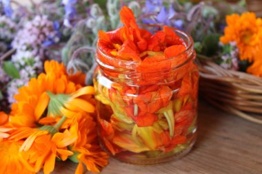Alkol, kalentula ve sepetin içinde salamura edilmiş turuncu nasturtiyum çiçeği..
