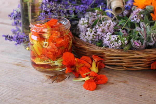 Alkol ve sepetin içindeki otlar turşulu turuncu nasturtium çiçeği..