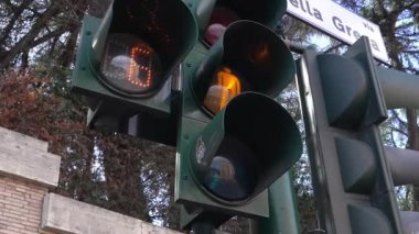İtalya, Roma 'da bir trafik lambası direğinin soldan sağa yakın çekimleri, sarı bir geri sayım zamanlayıcısıyla yayaların caddeyi geçmeleri için numaralarını gösteren kırmızı ışığı gösteriyor..