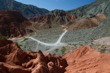 Altiplano. Kurak çöl ve renkli dağlar. Kanyonun karşısındaki yürüyüş yolunun manzarası. Purmamarca, Jujuy, Arjantin 'deki farklı minerallerden oluşan kumtaşı ve kayalık oluşumlar.