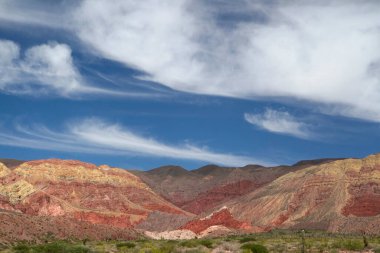 Manzaralı bulutlu mavi gökyüzünün altındaki güzel dağların manzarası.      