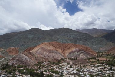 Altiplano dönüm noktası ve popüler bir yer. Jujuy, Arjantin 'deki Seven Color Hill' in eteğindeki Purmamarca köyünün hava manzarası. Kasaba binaları ve renkli dağlar açık bir günde.