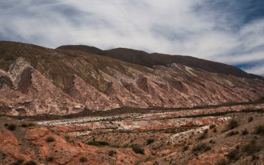 Manzaralı bulutlu mavi gökyüzünün altındaki güzel dağların manzarası.      
