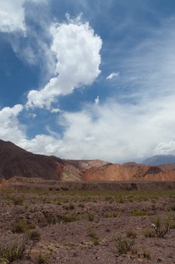 Manzaralı bulutlu mavi gökyüzünün altındaki güzel dağların manzarası.      