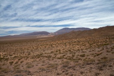 Manzaralı bulutlu mavi gökyüzünün altındaki güzel dağların manzarası.      