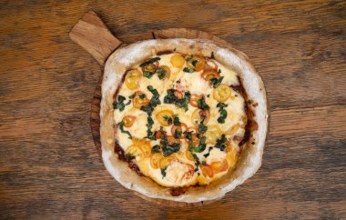 Mozzarella peynirli, sarımsaklı ve vişneli domatesli bir pizzanın ahşap masa manzarası..