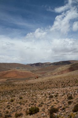 Manzaralı bulutlu mavi gökyüzünün altındaki güzel dağların manzarası.      