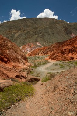 Jeoloji. Kırmızı ve turuncu kayalık oluşumlar. Renkli dağların arasındaki patika.