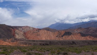 Manzaralı bulutlu mavi gökyüzünün altındaki güzel dağların manzarası.      
