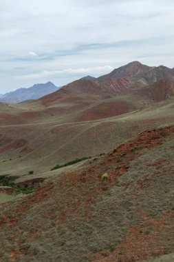 Manzaralı bulutlu mavi gökyüzünün altındaki güzel dağların manzarası.      