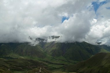 Yeşil vadi. Gökyüzü bulutlu ve popüler Cuesta del Obispo 'nun gökyüzü manzarası. Dağları aşan otlaklar, vadiler ve yollar.. 