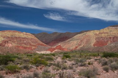 Manzaralı bulutlu mavi gökyüzünün altındaki güzel dağların manzarası.      