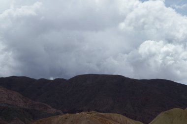 Alıntılar için ilham verici doğal bir altyapı. Bulutlar. Güzel beyaz ve bulutlu bir gökyüzünün altında kurak dağ sırasının zirvelerini görmek. 
