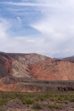 Manzaralı bulutlu mavi gökyüzünün altındaki güzel dağların manzarası.      