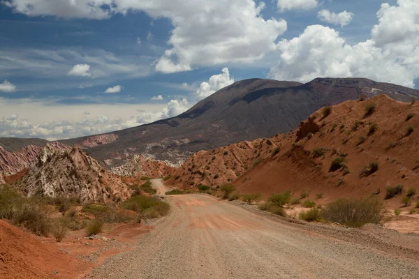 沿着泥泞的道路在岩石红色的山脉和沙漠中旅行 — 图库照片