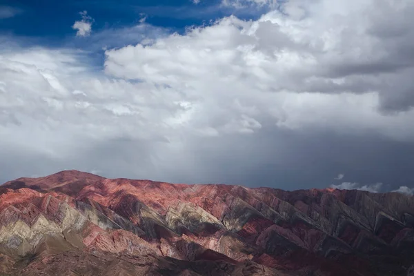 Renkli dağ sırası. Humahuaca, Jujuy, Arjantin 'deki popüler Horoncal dağlarının panorama manzarası. Güzel kaya ve mineraller bulutlu bir gökyüzünün altında desen ve doku. 