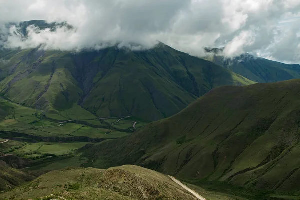 stock image Travel. View of the countryside road across the popular landmark Cuesta del Obispo. The grassland, valley and hills under a dramatic cloudy sky.