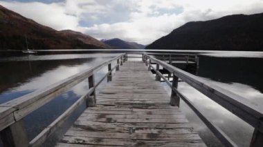 Ahşap iskeleli ve manzaralı dağları olan güzel göl manzarası.