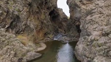 İHA 'yı kırıyorum. Nehri kayalık kayalıklara ve gizli mağaralara doğru takip eden hava görüntüleri. İHA kontrolü kaybediyor ve kaya duvarına çarpıyor..